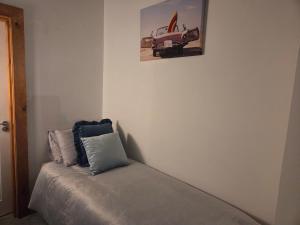 a bed in a room with a picture of a car on the wall at Downhill Beach Studio Suite in Coleraine