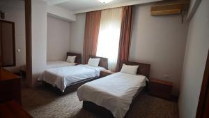 a hotel room with two beds and a window at Hotel Emka in Tetovo