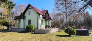 a small green house with a red roof at Willa Baśka in Chańcza