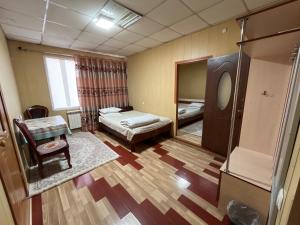 a room with two beds and a table and a mirror at Жетиген in Karakol