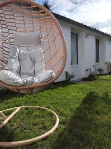 a wicker chair in a yard with a hose at Maisonnette avec Jardin, Piscine, Netflix in Vichy