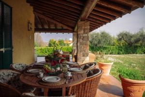a wooden table on a patio with chairs and a tableablish at Villa Mary in Montinelle