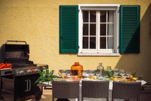 a table with a green window and a table with food at Villa Mary in Montinelle +35 photos