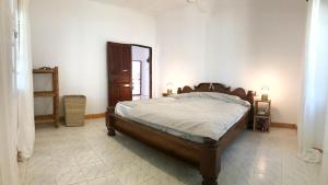 a bedroom with a large wooden bed in a room at House on the beach in Jambiani