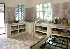 a kitchen with a sink and a stove in it at House on the beach in Jambiani +15 photos
