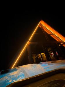 a house with a light on top of a snow covered roof at ALTURA Chalet in Muntele Băişorii