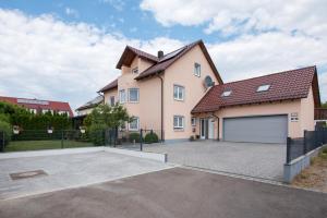 a large pink house with a garage at Ferienwohnung Regel in Lauingen