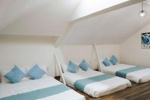 two beds in a room with blue pillows at Nostalgia Villa Dalat in Ấp Ða Lợi