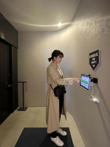 a woman standing in a room with a laptop at 古街のアトリエ in Utazu