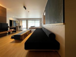 a living room with a black couch and a television at 古街のアトリエ in Utazu