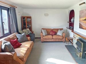 a living room with two couches and a fireplace at The Gazebo in Marazion