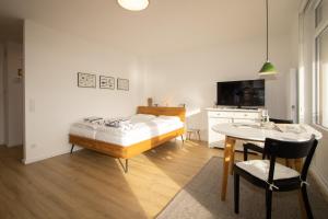 a bedroom with a bed and a table and a television at Sylt for Friends in Hörnum