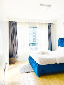 a bedroom with a large bed with a large window at Urban Homes-Two Bedroom Near JKIA Airport in Nairobi