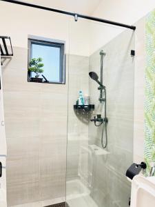 a shower with a glass door in a bathroom at Urban Homes-Two Bedroom Near JKIA Airport in Nairobi +23 photos