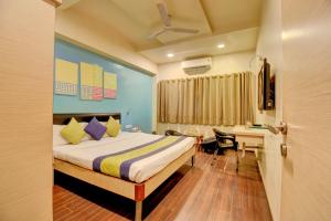 ein Hotelzimmer mit einem Bett, einem Schreibtisch und einem Tisch in der Unterkunft MY Bizz Hotel Sapna in Pune