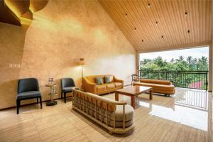 a living room with furniture and a balcony at Bumi Anyom Resort by Nexura in Pikatan