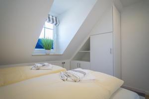 a white bedroom with two beds and a window at Lister Tor 11 in List