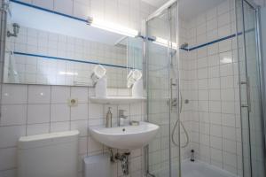 a bathroom with a sink and a shower and a toilet at Lister Tor 11 in List