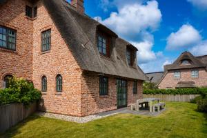 a brick building with a picnic table in the yard at Lachmöwe in List