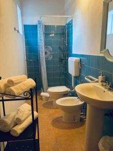 a blue bathroom with a toilet and a sink at Dépendance Liscio in Filicudi +27 photos