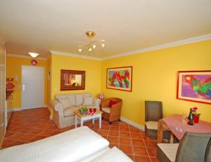 a living room with yellow walls and a couch and a table at Wattenblick 51-35 in List