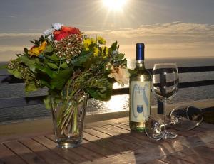 a table with a vase of flowers and a bottle of wine at Wattenblick 51-35 in List