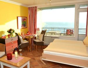 a bedroom with a bed and a table and a balcony at Wattenblick 51-35 in List