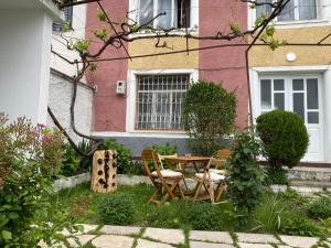 a garden with a table and chairs in front of a building at Vila Llulla in Krujë +66 photos
