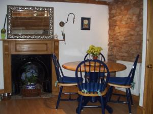 a dining room with a table and chairs and a fireplace at Upper Cottage, Brixham in Brixham