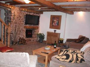 a living room with two couches and a stone fireplace at Upper Cottage, Brixham in Brixham
