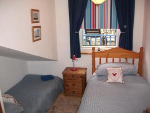 a bedroom with two twin beds and a window at Upper Cottage, Brixham in Brixham