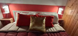 a bed with red walls and red pillows on it at Casa APOLLO in Palmanova