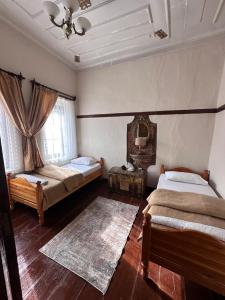 ein Schlafzimmer mit zwei Betten und einem Fenster in der Unterkunft Pergamonpension in Bergama