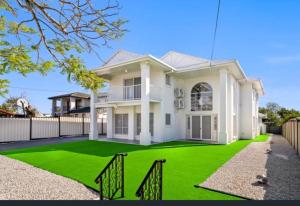 a large white house with a green lawn at Darra guest house in Brisbane