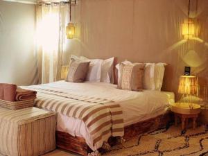 a bedroom with a large bed with white sheets and pillows at Casa house in Merzouga