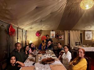 a group of people sitting around a table in a tent at Casa house in Merzouga