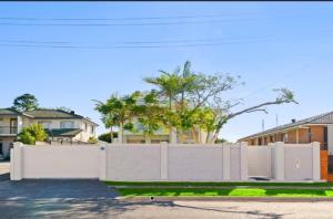 a white fence in front of some houses at Darra guest house in Brisbane