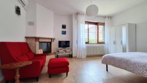 a bedroom with a red chair and a fireplace at Maya Suite & Garden in Sarteano