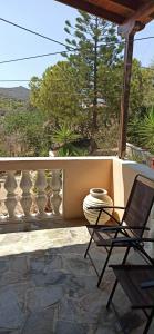 a chair and a vase sitting on a porch at V&M Residence Upper Level in Mesagrós +7 photos