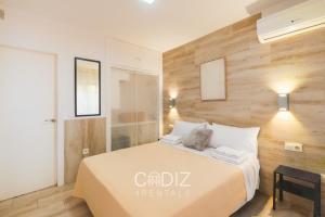 a bedroom with a bed and a wooden wall at Hospederia IMAR by Cadiz4Rentals in Cádiz