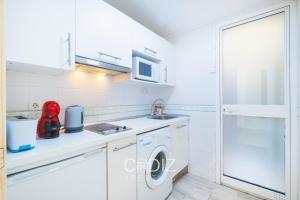 a kitchen with a washing machine and a microwave at Hospederia IMAR by Cadiz4Rentals in Cádiz