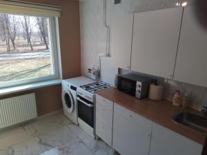 a small kitchen with a stove and a microwave at Svečių butas in Šiauliai +7 photos