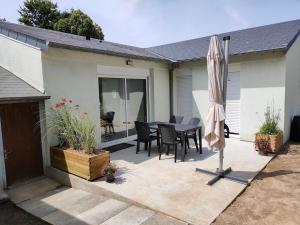 a patio with an umbrella and a table and chairs at TyCoCoon in Lannion