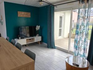 a living room with a flat screen tv and a table at TyCoCoon in Lannion
