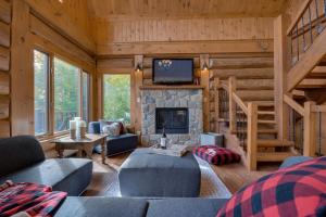 a living room with a fireplace and a tv at Belvedere sur le Lac Lodge in Sainte-Adèle +25 photos