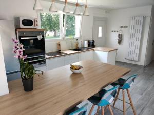 a kitchen with a wooden table and blue chairs at TyCoCoon in Lannion