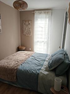 a bedroom with a large bed with a window at TyCoCoon in Lannion