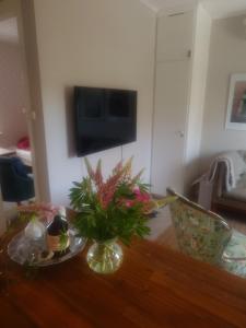 a living room with a table with a vase of flowers at Stuga Sannerud Tived in Tived +33 photos