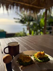 a plate with a sandwich and a cup of coffee at Torre Bella Gardens in Arco da Calheta