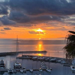 a sunset over a marina with boats in the water at Cavour 66 Apartment in Ventimiglia